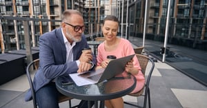 A corporate founder and a wealth advisor examining an estate balance sheet to verify accredited status parameters.