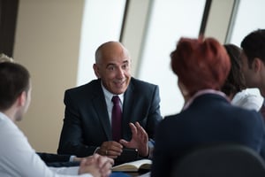 A professional advisor discussing a quarterly performance report during an investment committee meeting